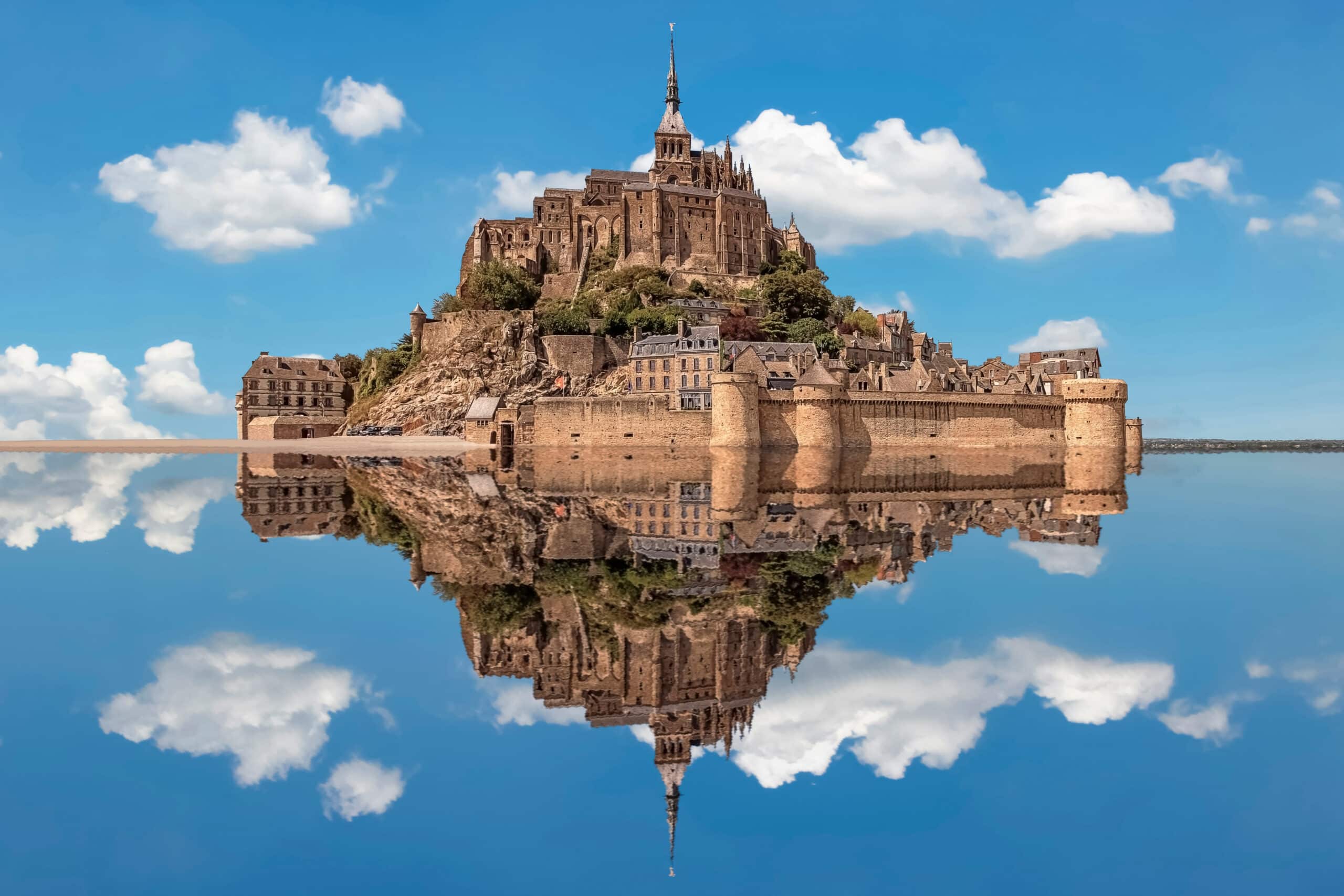 Mont Saint-Michel reflectit en la mar