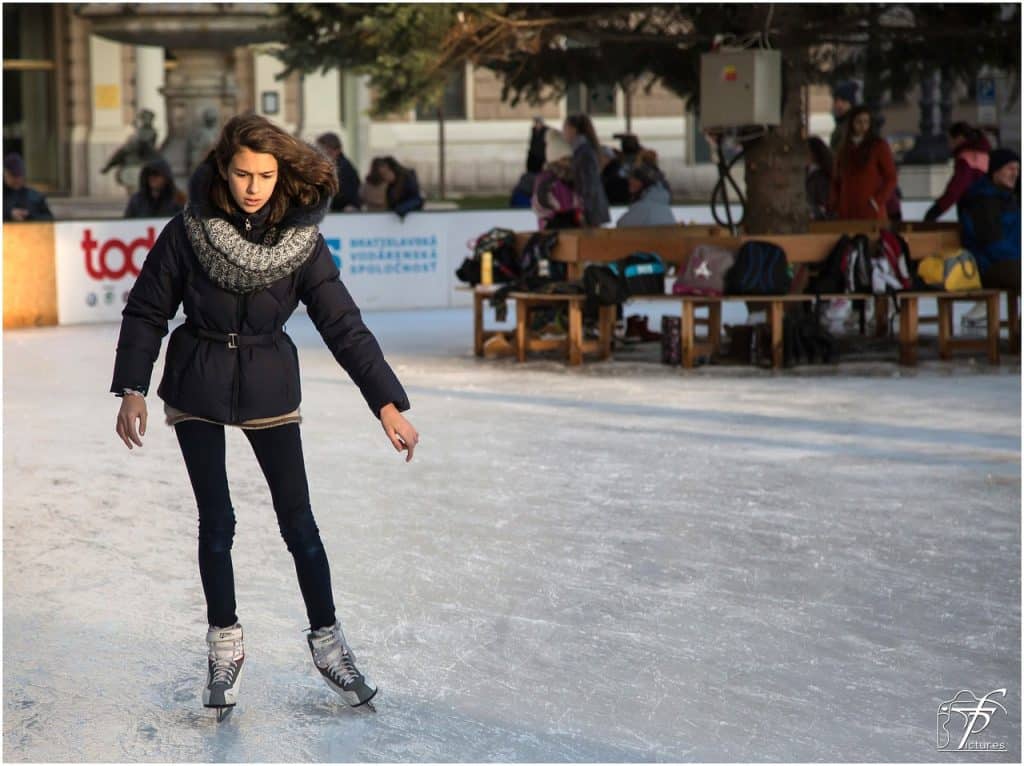 Chica patinando sobre hielo en una pista de hielo