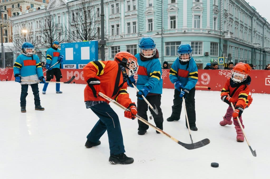 Equipos de chicos jóvenes jugando en una pista de hielo a hockey sobre hielo