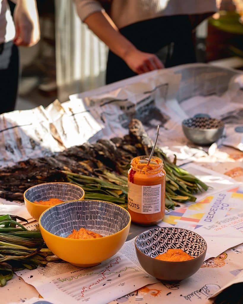 Mesa con calçots y salsa romesco