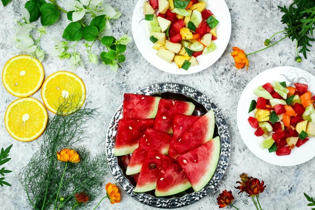 Mesa con platos de verano: sandía y otras frutas.