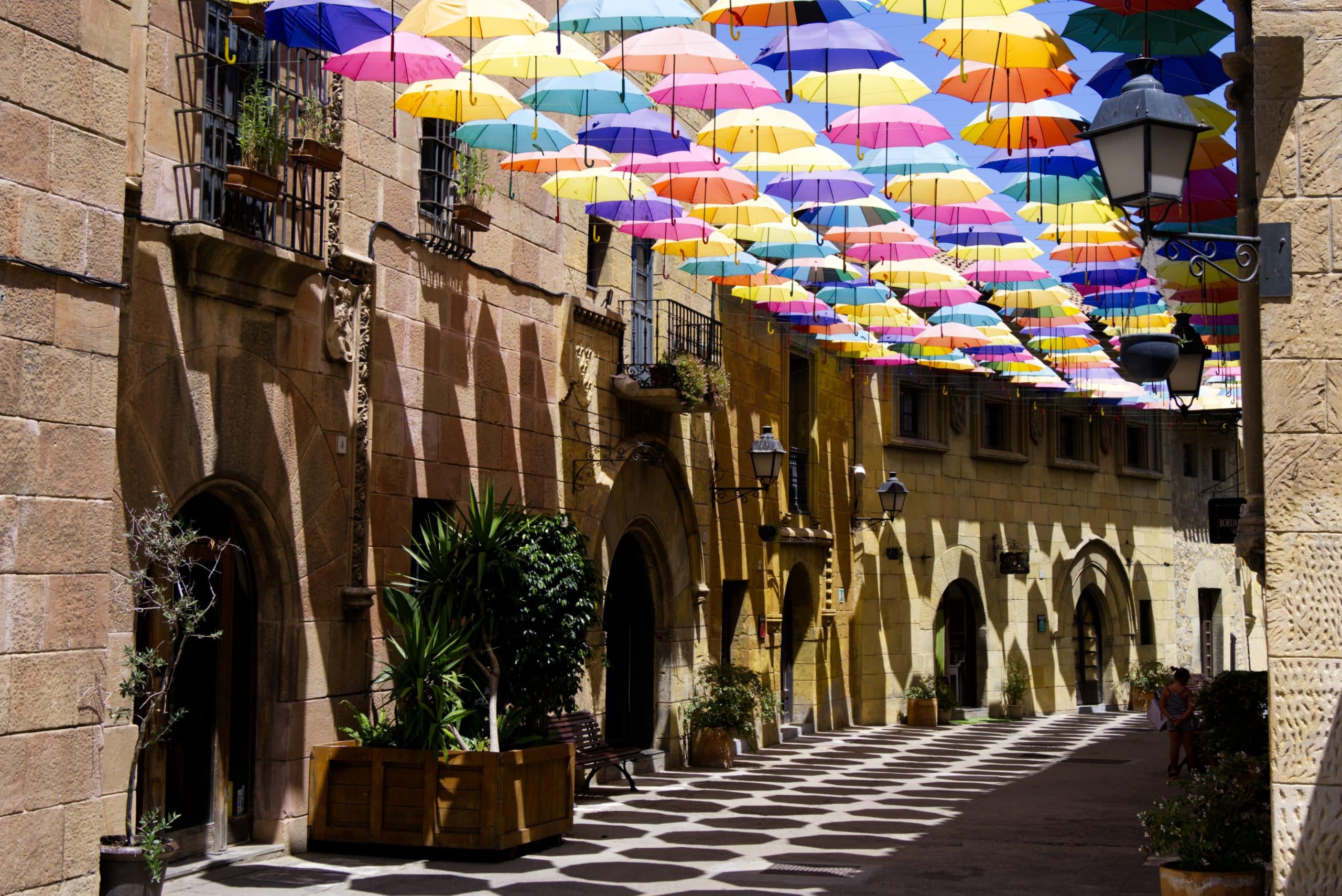 Calle del Poble Espanyol con paraguas de colores colgando